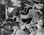 An aerial reconnaissance photograph of the Auschwitz concentration camp showing a partial view of the Birkenau (Auschwitz II) camp including one of the gas chambers and crematoria.