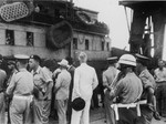British soldiers on the pier in Haifa harbor oversee the offloading of passengers from the illegal immigrant ship, Exodus 1947, while a United Nations official (in the white suit) observes the process.