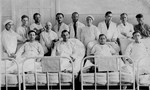 Doctors and nurses at the Jewish hospital in Biala Rawska pose with four of their patients who are lying in bed.
