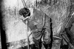 David Lowenthal stands knee-deep in water in the engine room of the President Warfield after the gale that nearly sank the ship during its first attempt to cross the Atlantic Ocean.