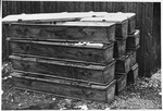 Postwar view of a pile of coffins in the Dachau concentration camp.