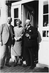 Mortiz and Recha Weiler stand by the entrance to a building with a friend, Julius Stein.
