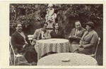 A German Jewish family sits around an outdoor table.