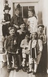 Group portrait of Jewish children dressed in Purim costume at the entrance to a home in Essen.