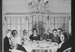 Jewish friends who have met for tea, including the parents of Anne Frank, pose around a table in a private home in Mannheim, Germany, shortly before many of them fled the country as refugees of the Nazi regime.