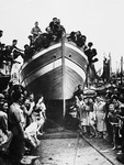 Jewish DPs gather in and around their newly constructed fishing boat during its christening ceremony at the Migdalor hachshara, a maritime Zionist collective in Fano, Italy.