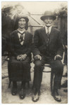 Close-up portrait of a religious Jewish couple sitting in their yard.