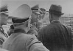 Reichsfuehrer SS Heinrich Himmler converses with Max Faust (wearing the fedora) during a tour of the Monowitz-Buna building site.