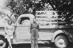 Jewish refugee youth pose in front of their father's farm truck which bears the name of the former family firm in Czechoslovakia.