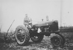 Slovak-Jewish refugee Nandor Muller driving a tractor he bought to work his farm in southern Ontario.