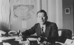 Chiune Sugihara sits at a desk in his office.