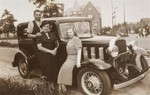 The donor's mother, Chaya Gar, poses next to a car with friends, during her return visit to Kron in the summer of 1938.
