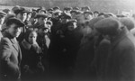 Jacob Pat, a representative of an American Jewish Labor Committee, surrounded by Jewish survivors on the site of the former Warsaw ghetto.