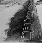 Soldiers unload coal from a train after liberation at the site of what had previously been the Umschlagplatz of the Warsaw ghetto.