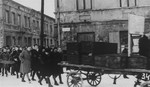 Jewish survivors walk behind a wagon of coffins during a funeral procession through the snow covered streets of Czestochowa.