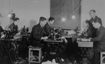 Jewish men work at sewing machines in a clothing workshop in the Bochnia ghetto.