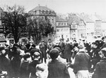 Local residents look on as a group of Jewish deportees arrives at the Fränkischen Hof assembly center during a deportation action in Kitzingen.
