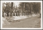 American soldiers stand behind a row of graves at the mass funeral in Ludwigslust on the palace grounds of the Archduke of Mecklenburg, where they forced the townspeople to bury the bodies of prisoners killed in the Woebbelin concentration camp.