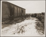 Under the supervision of American soldiers, German civilians exhume the corpses of prisoners killed in a barn and buried in a mass grave by the SS.