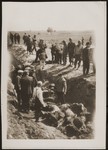 Under the supervision of American soldiers, German civilians exhume the bodies of concentration camp prisoners killed by the SS in a barn just outside of Gardelegen.