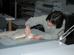 Textile conservator Gail Singer prepares a mount to display a dress worn by a Jewish child while living in hiding in Poland during World War II.