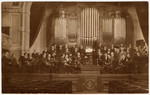 Members of a Polish symphony, including many Jewish musicians, pose on stage with their instruments.