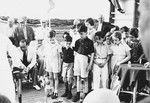 A group of children observe a game on the deck of the St.