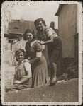 Three young Jewish friends pose outside wearing armbands in the Bedzin ghetto.