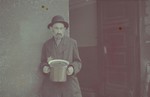 A Jewish man holding a pot in the Lodz ghetto.

Original German caption: "Type" (man), #127.