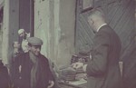 Hans Biebow purchases books from a street vendor in the Lodz ghetto.