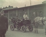 Mordechai Rumkowski rides through the Lodz ghetto in a horse-drawn carriage.