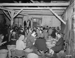 Female survivors peel potatoes in a  barracks in the Bergen-Belsen concentration camp.