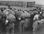 British troops look on as the last Typhus ridden barracks in Belsen are burned.