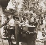 Jewish refugees from the Kladovo transport queue up to receive a meal at a refugee camp.