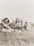 Three teenage girls sing with guitar accompaniment at the Zionist youth camp in Kladovo.