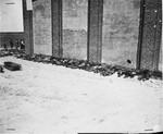 Corpses lined up on the west side of the barn with a visible hole supposedly made by a Panzerfaust.