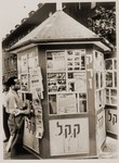 A Jewish DP reads the announcements posted on the newspaper kiosk at the Neu Freimann displaced persons camp.