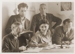 Members of the administrative staff of the Schlachtensee displaced persons camp pose in the office of UNRRA camp director Schwartzberg.