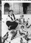 Felicja Pleszowski helps her son Adam feed pigeons in a courtyard in Krakow.