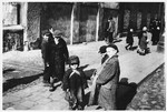 A group of children are gathered on a street corner in the Warsaw ghetto.