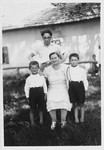 Ewa Rosenbach poses with her two sons and a neighbor in front of her home in rural Poland.