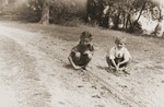 Zofja Fajnsztejn, a Jewish child in hiding, plays with a Polish child in a Warsaw park.