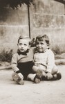 Two young children sit outside the La Pouponniere children's home in Uccle.