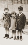Three young children pose outside the La Pouponniere children's home in Uccle.