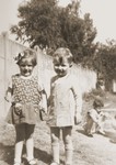 A young boy and girl pose in the yard of the La Pouponniere children's home in Uccle.