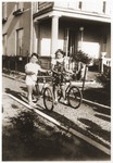 Alicja Fajnsztejn and her cousin Ryszyard ride their bicycles in front of their summer home in Mlociny, outside of Warsaw.