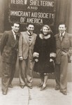 Alicja Fajnsztejn poses with friends from the Foehrenwald displaced persons camp in front of a HIAS sign in the port of New York after her arrival aboard the SS Marine Jumper.