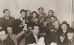 Jews raise their glasses and wine bottles in a toast at a social gathering in Sosnowiec.