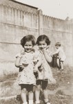 Two young girls pose in the yard of the Homes des Moineaux in Uccle, Belgium.