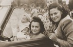 Jewish friends pose in a car while on an outing with their children in Sosnowiec.